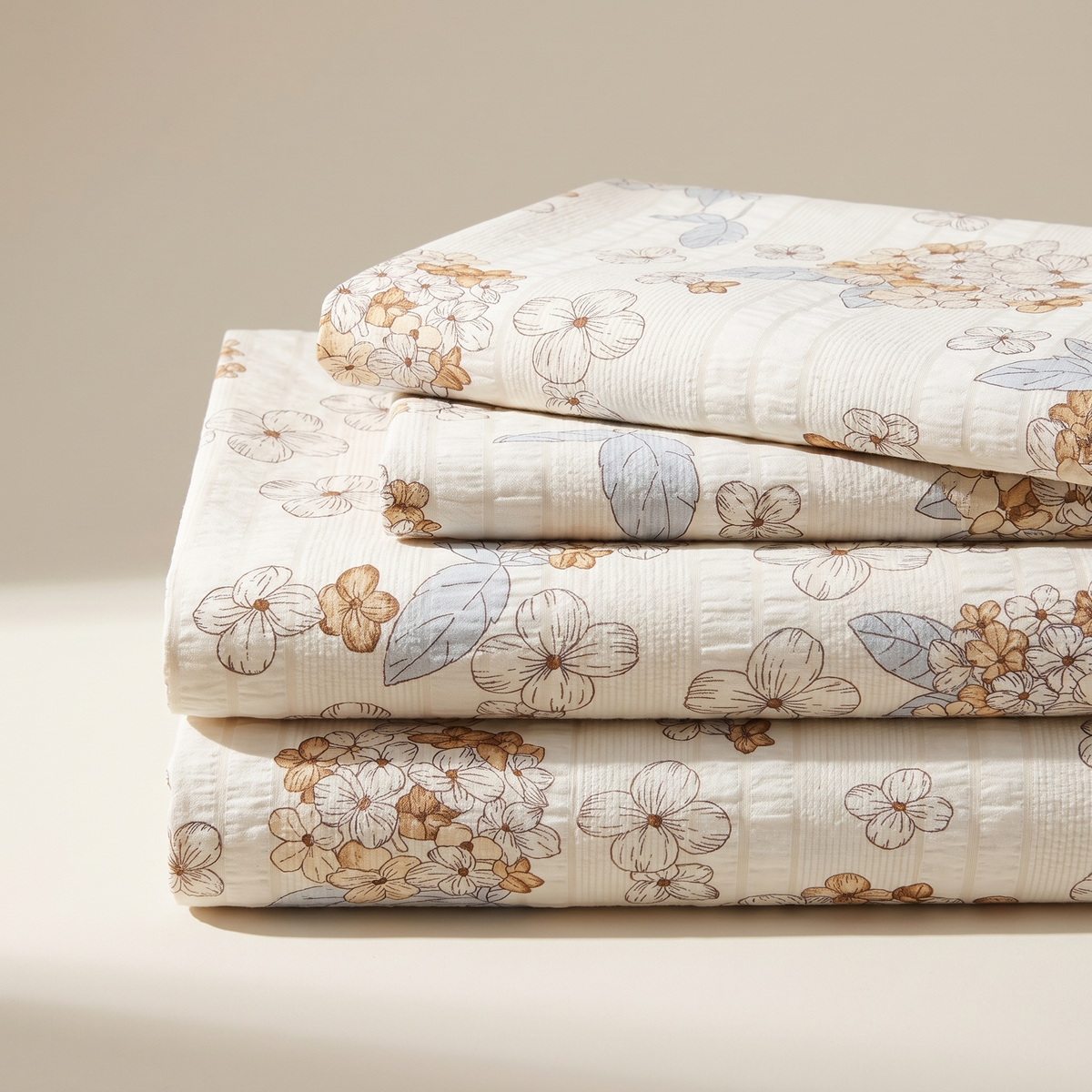 Petal Sheet Set, folded stack, tan and white cherry blossom on cream