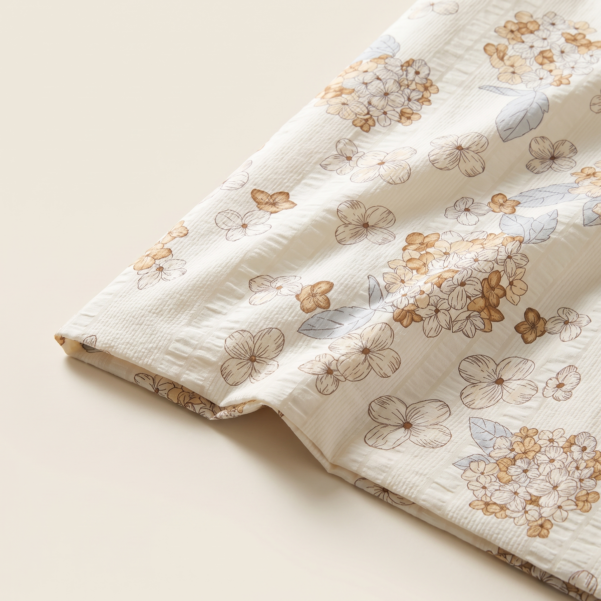 Petal Duvet Cover Set, fold detail, tan and white cherry blossom on cream